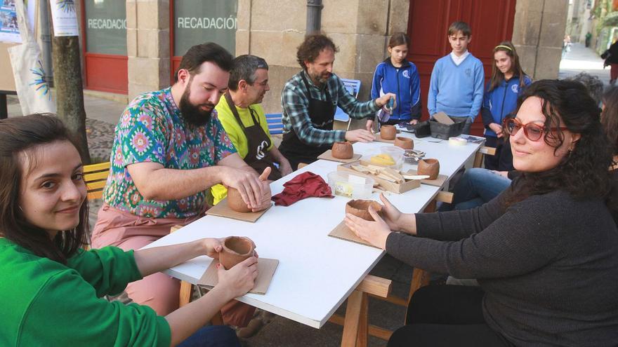 Asistentes al primer taller de cerámica, impartido por el artesano Mario López, en la Praza da Imprenta.   |  IÑAKI OSORIO