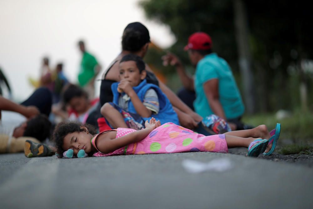 Families rest roadside while traveling with a ...