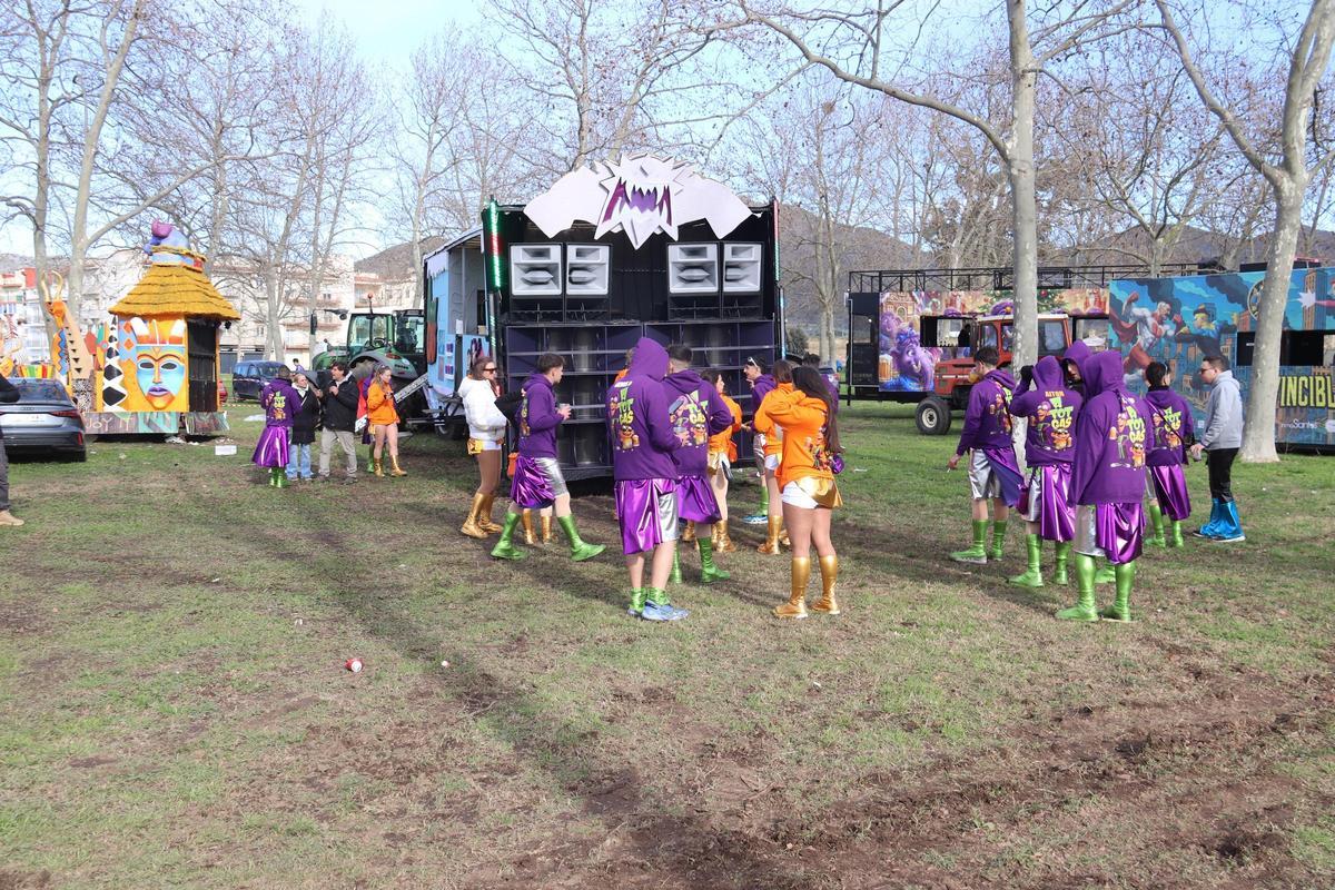 Alguns membres d'una de les comparses que sortien al carnestoltes de Roses ballen en un aparcament tot i el vent que feia