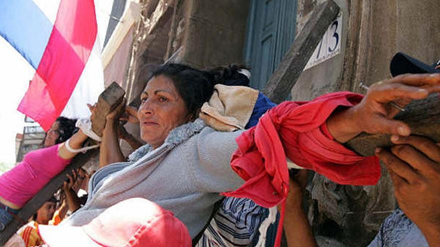 Dos mujeres de grupos de denominados &quot;sin techo&quot; (ocupantes ilegales de viviendas) se dejan crucificar hoy, 5 de diciembre de 2008, en Asunción (Paraguay), durante una protesta para exigir al Gobierno de Fernando Lugo la destitución o renuncia del ministro de la Secretaría de Acción Social, Pablino Cáceres.