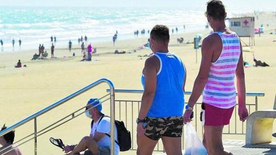 Turistas acceden con mascarillas en una playa. | | ANDRÉS CRUZ