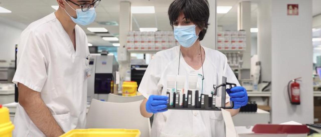 Dos técnicos de laboratorio con muestras de posibles positivos de viruela del mono, en España.