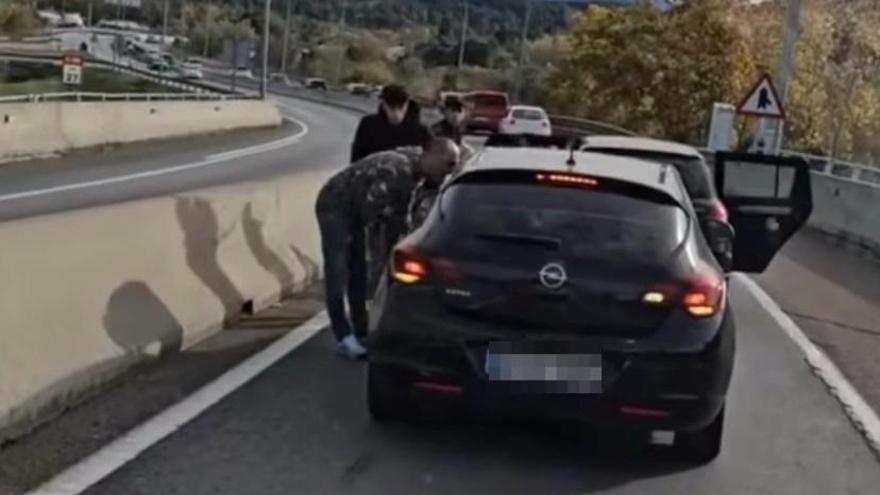 Els ocupants d'un dels vehicles increpant als de l'altre enmig de la via