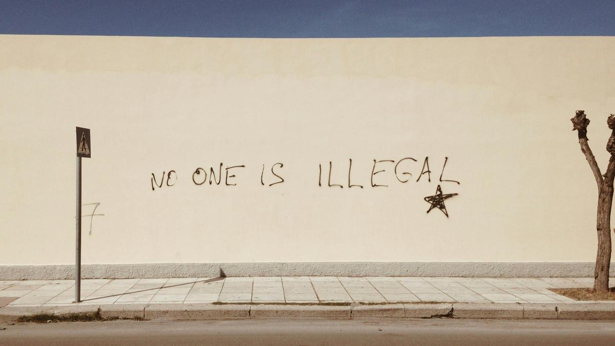 Un mur amb una pintada on s'hi llegeix 'No one is illegal'.