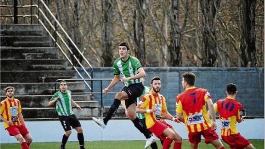 Lluc Banús guanya una pilota aèrea davant els jugadors del Manlleu.