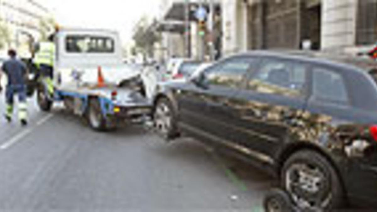 Una grúa retira un coche de una zona verde de Barcelona.