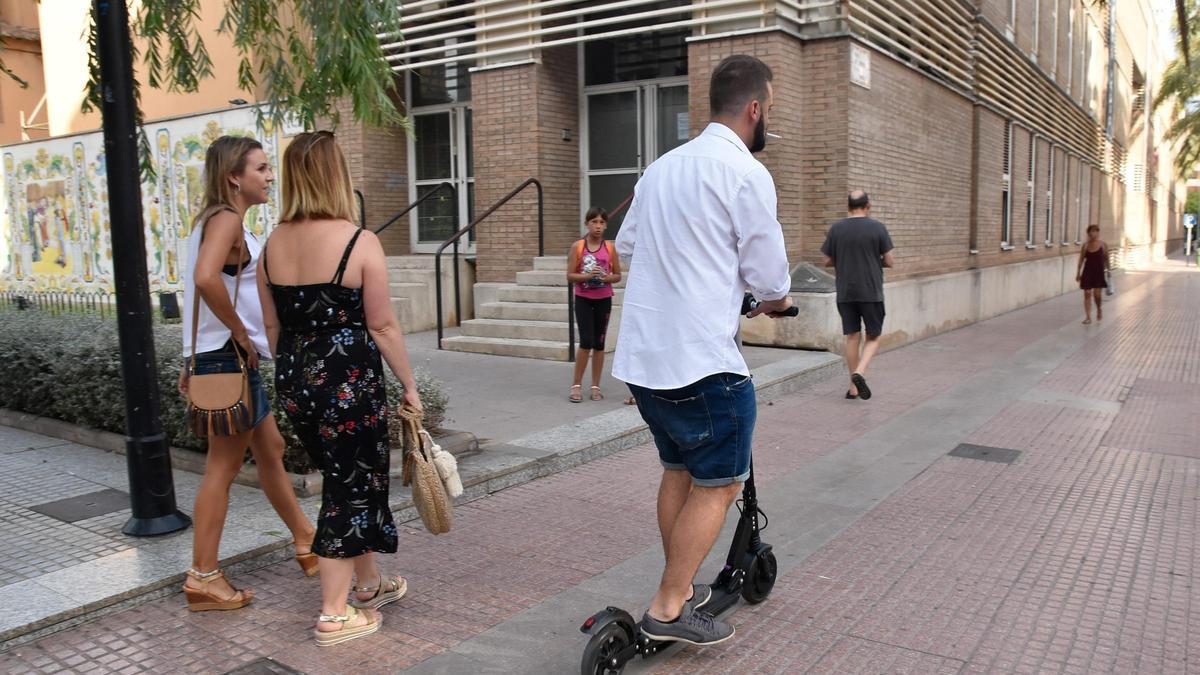 Ún hombre con un patinete.