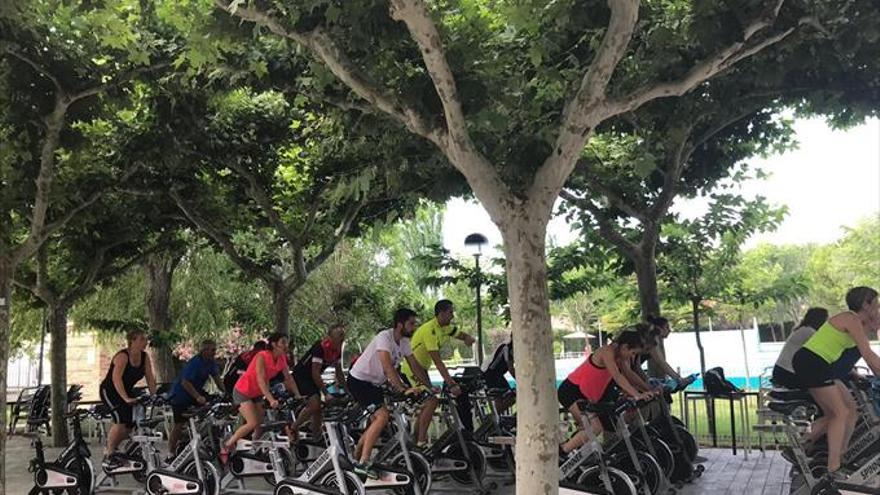 Los vecinos asisten a unas clases de spinning en las piscinas