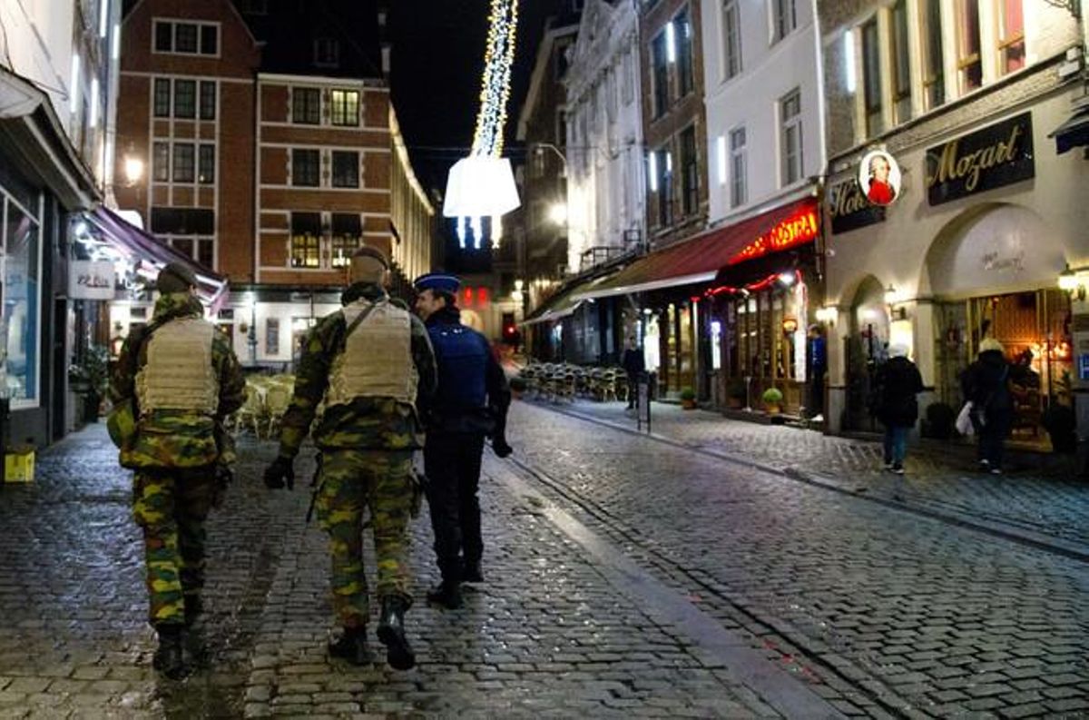 La policia patrulla a prop de la Gran Plaça de Brussel·les, desèrtica, a la nit.