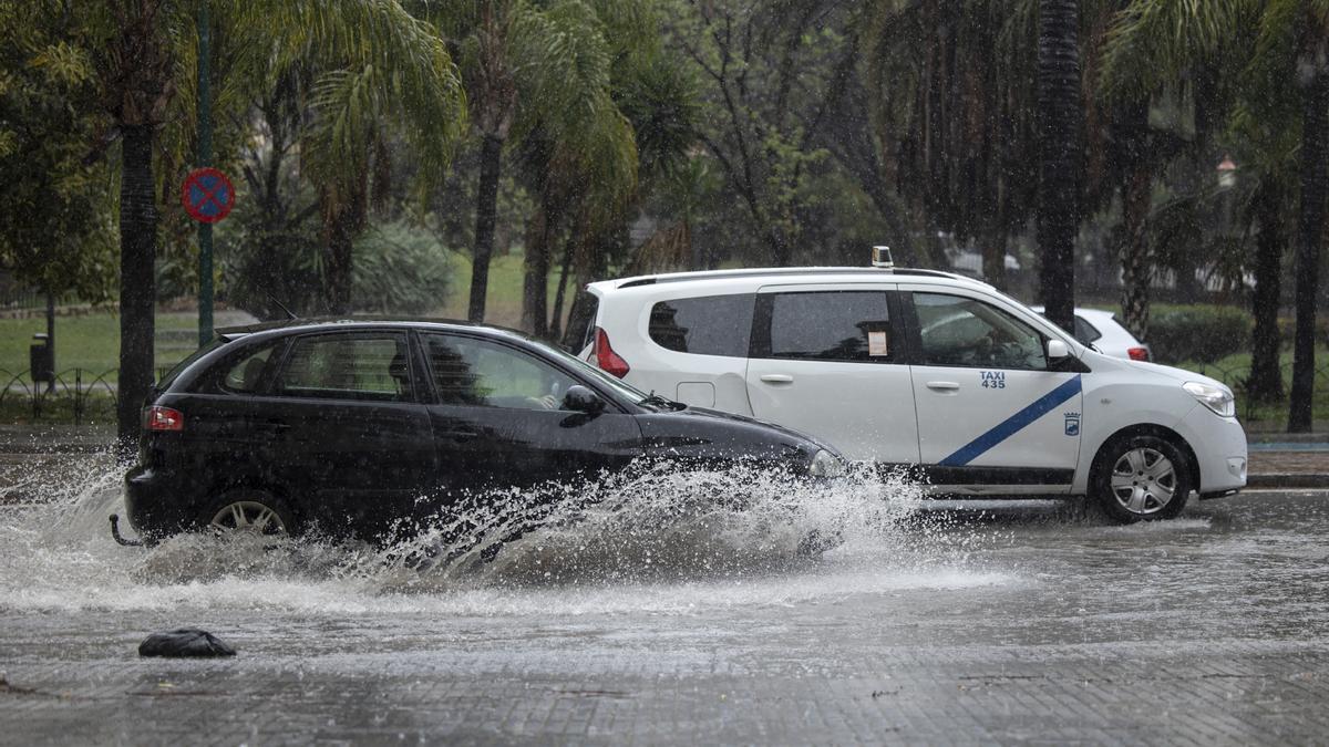 Varios coches circulan bajo la lluviaen un municipio de Andalucía.