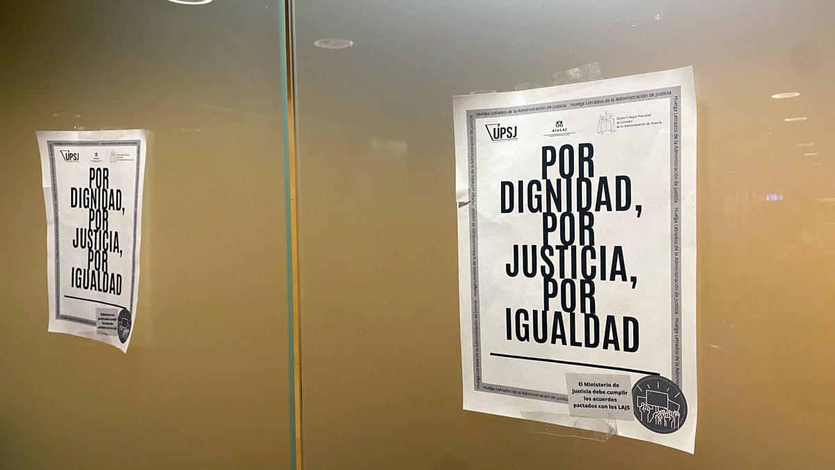 Cartells de la vaga de lletrats penjats en una sala de vistes de l’Audiència de Girona