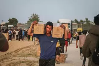 Los palestinos desplazados recogen la ayuda alimentaria que entró en el sur de la Franja de Gaza.