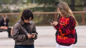 Un grupo de jóvenes universitarios consulta el teléfono. 