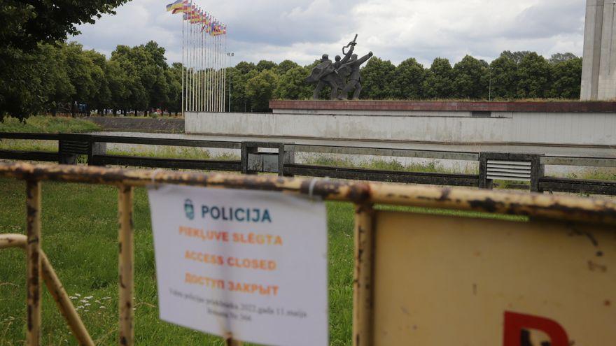 Banderas letonas y ucranianas junto a una de las estatuas del Memorial de la Victoria de Riga (Letonia), cerrado por la policía antes de que sea desmantelado.