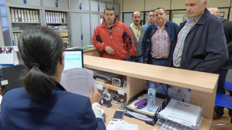 Por la izquierda, Carlos García, José Antonio Fernández, Manuel La Fuente, Fernando Barrero y José Manuel Fernández, vecinos de Las Montañas, entregan las firmas en la oficina del registro cangués.