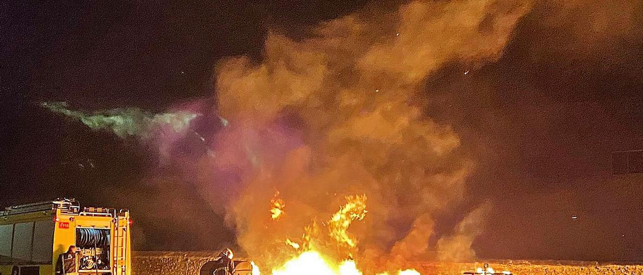 Bomberos extinguiendo el incendio de los contenedores, en el distrito de Ciaño, en la noche del viernes.