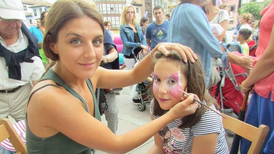 Rebeca Bermúdez pintando la cara a la pequeña Olaya Posada.