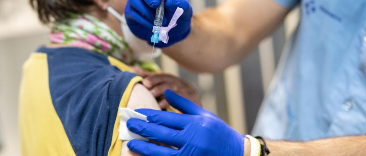 Una mujer recibe la vacuna de la gripe.