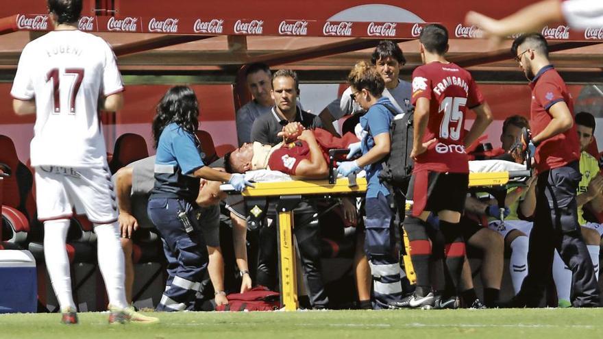 Xisco Campos, con un collarín, es conducido a la lambulancia tras ser inmovilizado.