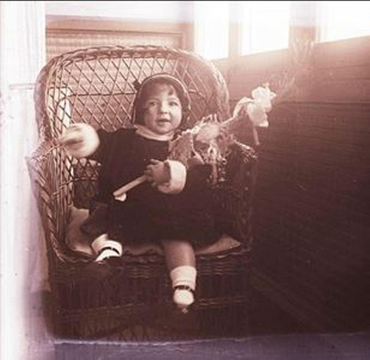 Retrat de la nena Rosa Masó asseguda en una butaca, a la galeria de la casa Masó, el dia de Rams de l’any 1923.