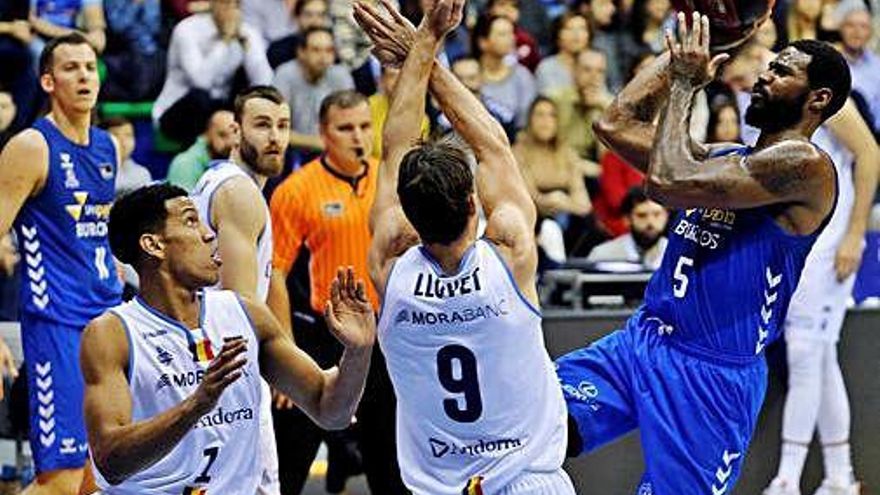 El local Earl Clark llança a cistella davant de Nacho Llovet i Tyson Pérez