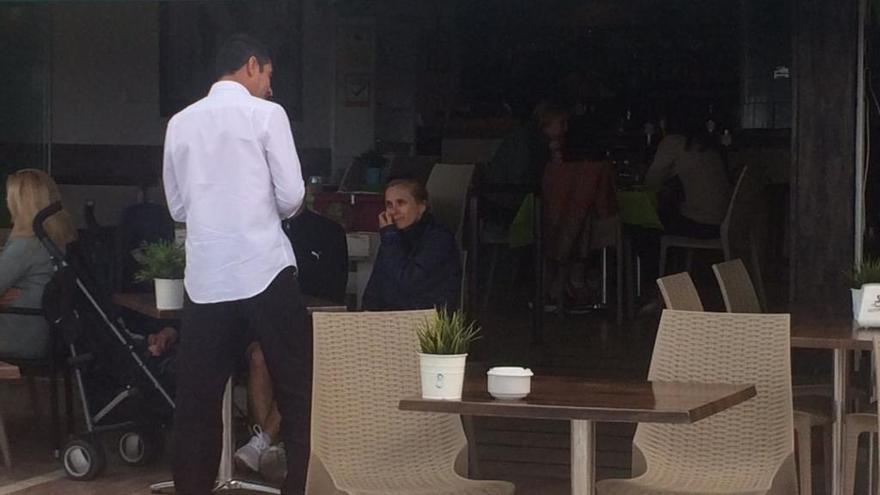 Un camarero atiende a unos clientes en una cafetería del paseo marítimo de Marbella.