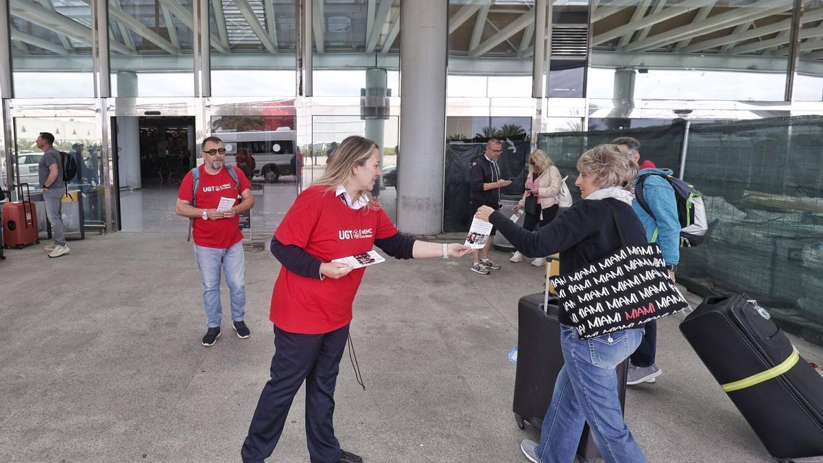 Una sindicalista de UGT le entrega un folleto de la campaña a una turista.