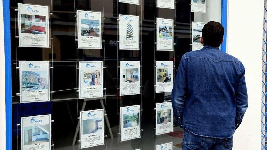 Un hombre observa ofertas de venta de pisos en una inmobiliaria de A Coruña.