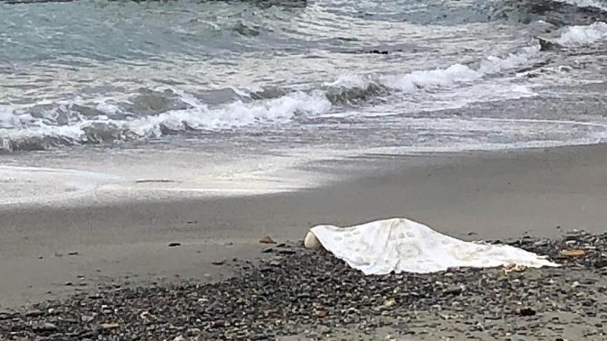 Una manta cubre el cadáver en la playa de La Herradura.