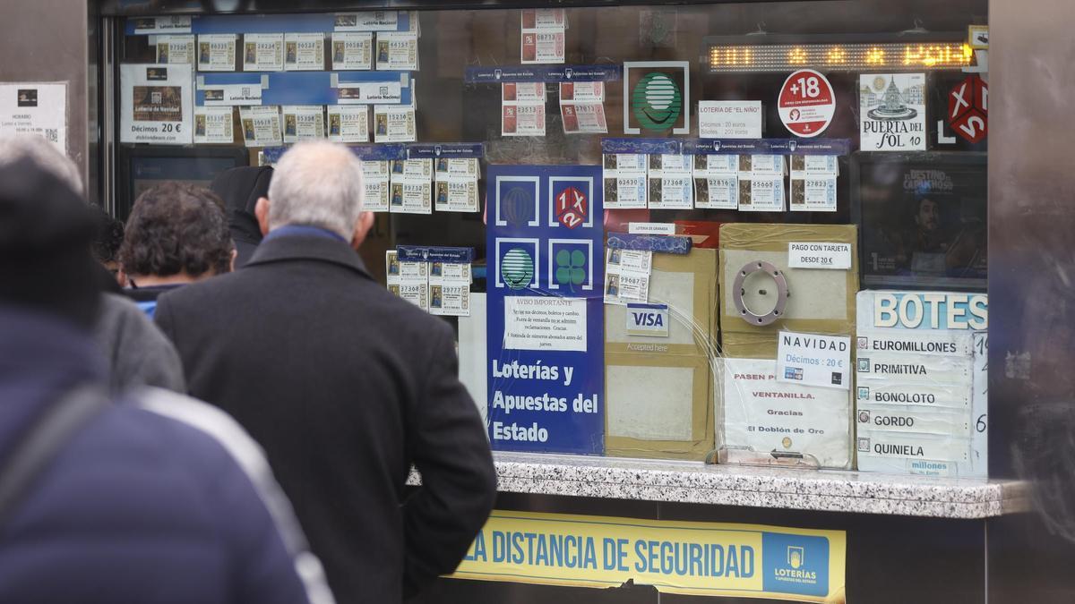 Varias personas en una administración de lotería de Navidad de la Puerta del Sol cuando quedan menos de tres semanas para el Sorteo Extraordinario de la Lotería de Navidad, a 7 de diciembre de 2021, en Madrid (España). Como cada año, la Lotería de Navidad.