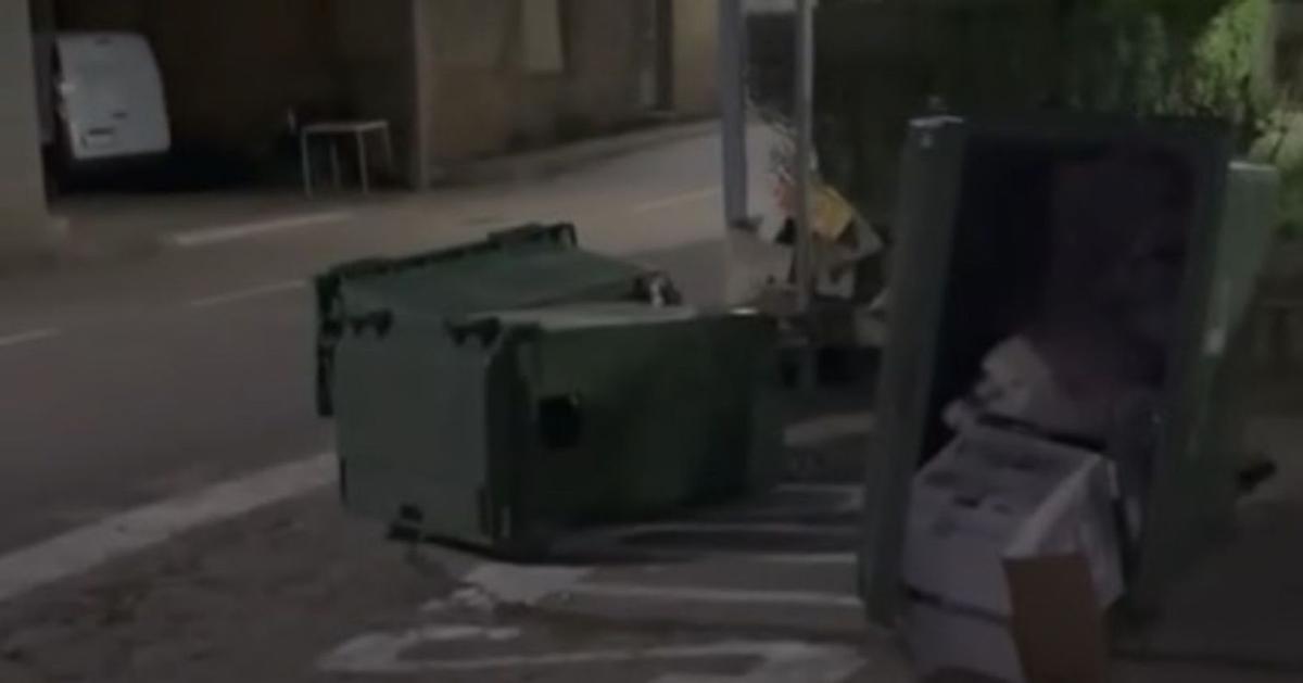 Arriba, contenedores volcados y la basura por la calle, a la izquierda, una puerta rota a patadas. | CEDIDAS