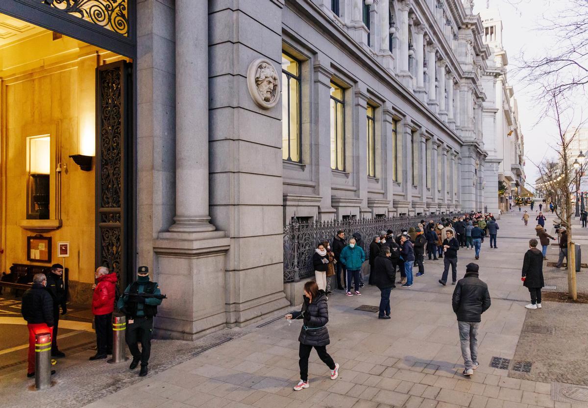 Varias personas hacen cola para contratar Letras del Tesoro en el Banco de España (Madrid).