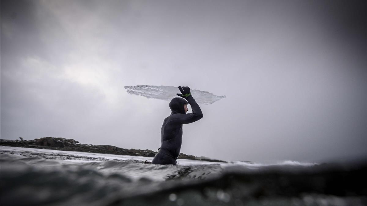 Foto-ensayo sobre el surfista sueco Pontus Hallinque, quien sostiene un pedazo de su tabla de surf de hielo derritiendose, en las islas Lofoten, sobre el Círculo Polar Ártico .