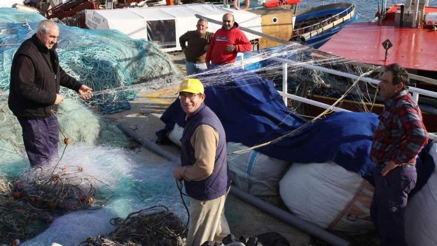 Un grupo de marineros de O Grove mientras preparan sus redes antes de salir a faenar.