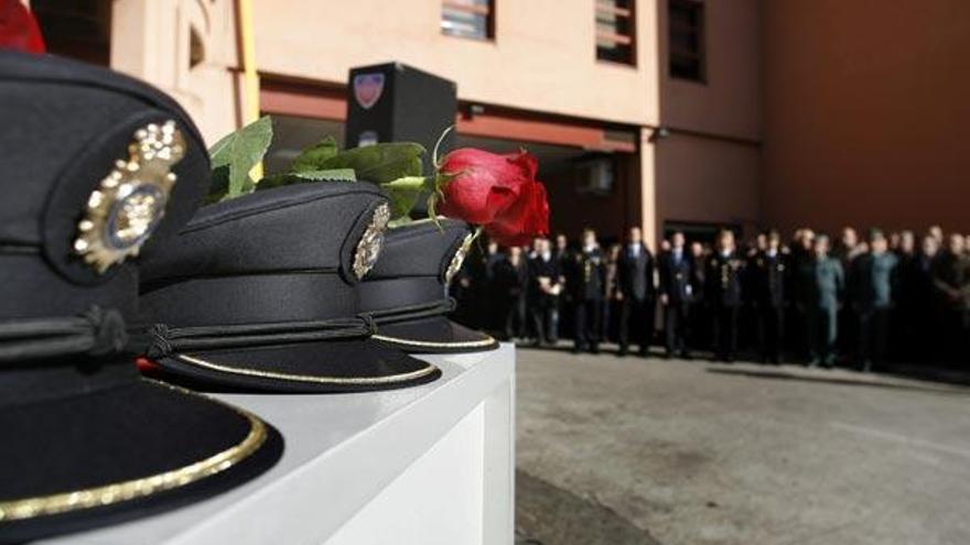 Unas rosas reposan sobre las gorras de los tres agentes del Cuerpo Nacional de Policía fallecidos en la Playa del Orzán, en A Coruña, durante el acto de homenaje que se les ha rendido esta mañana.