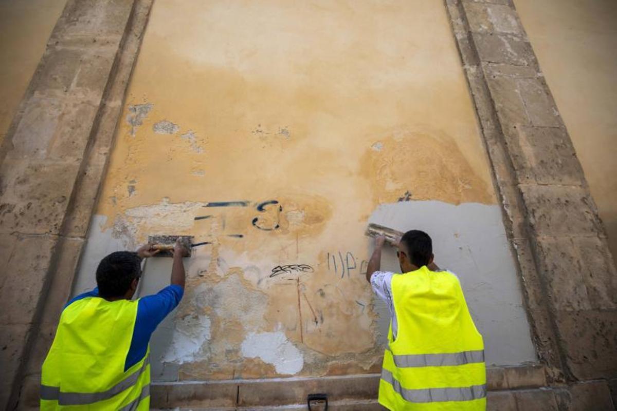 Dos operarios trabajan en la limpieza de una pared de Santa Magdalena. | G. BOSCH