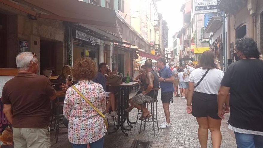 Personas paseando y consumiendo en la calle mayor llanisca.