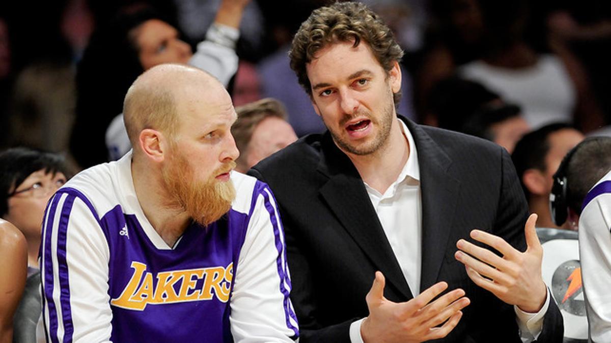 Pau Gasol, de baja, conversa con Chris Kaman durante el partido contra los Suns