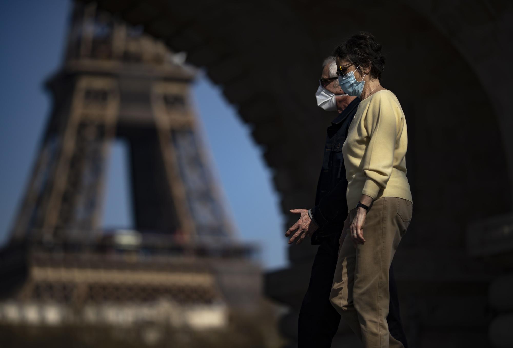 Dos personas mayores pasean por los alrededores de la torre Eiffel