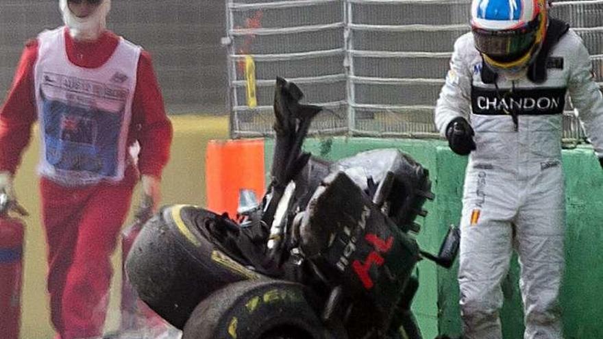 Alonso camina al lado de su coche, destrozado.