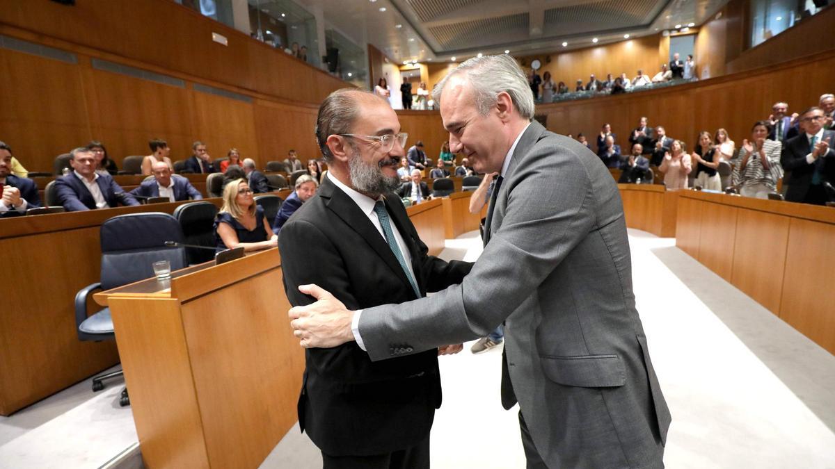 Los presidentes Jorge Azcón y Javier Lambán se saludan en el pleno de investidura del primero, en las Cortes de Aragón.