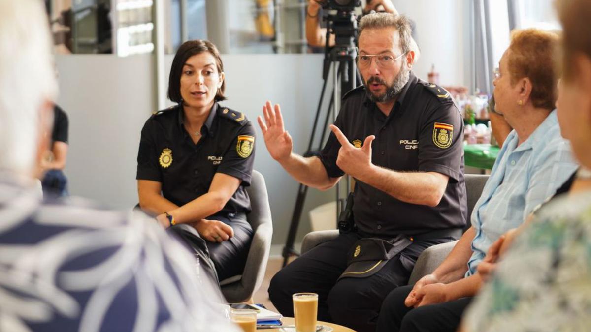 La policía Laura García y Carlos Muñoz, portavoz de la unidad de la Policía Nacional, dan a los mayores pautas contra las estafas en l’Esplai de Can Ventosa de Vila. 