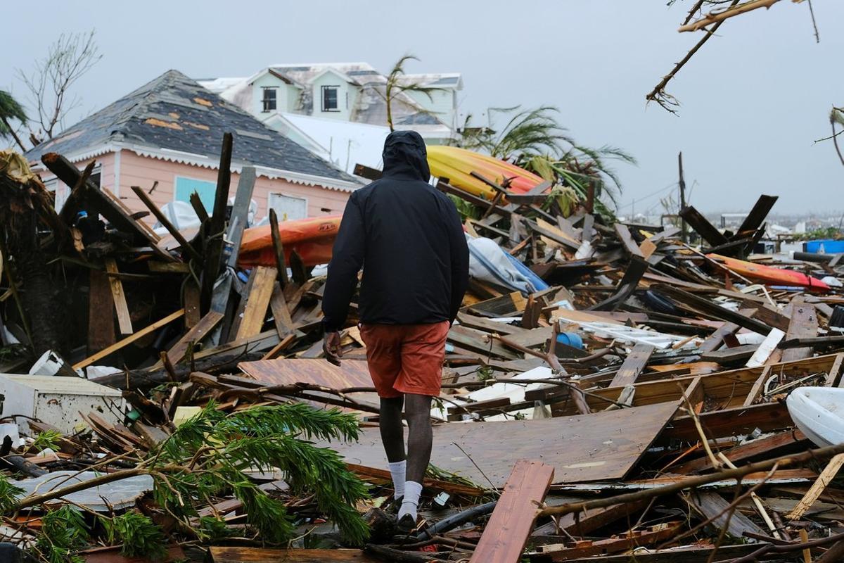 FILE PHOTO: A man walks through the rubble in the aftermath of Hurricane Dorian on the Great Abaco island town of Marsh Harbour, Bahamas, September 2, 2019. REUTERS/Dante Carrer/File Photo