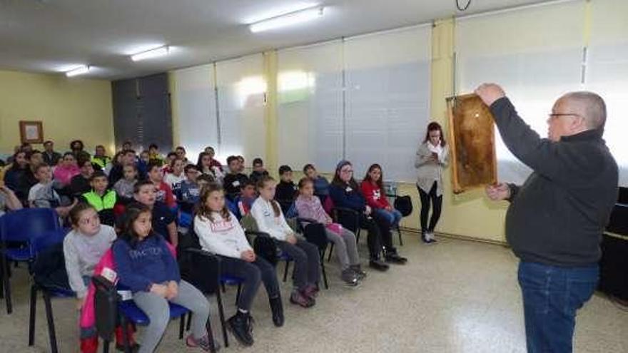 El apicultor Tino Gómez muestra un panal a los escolares de Navelgas.