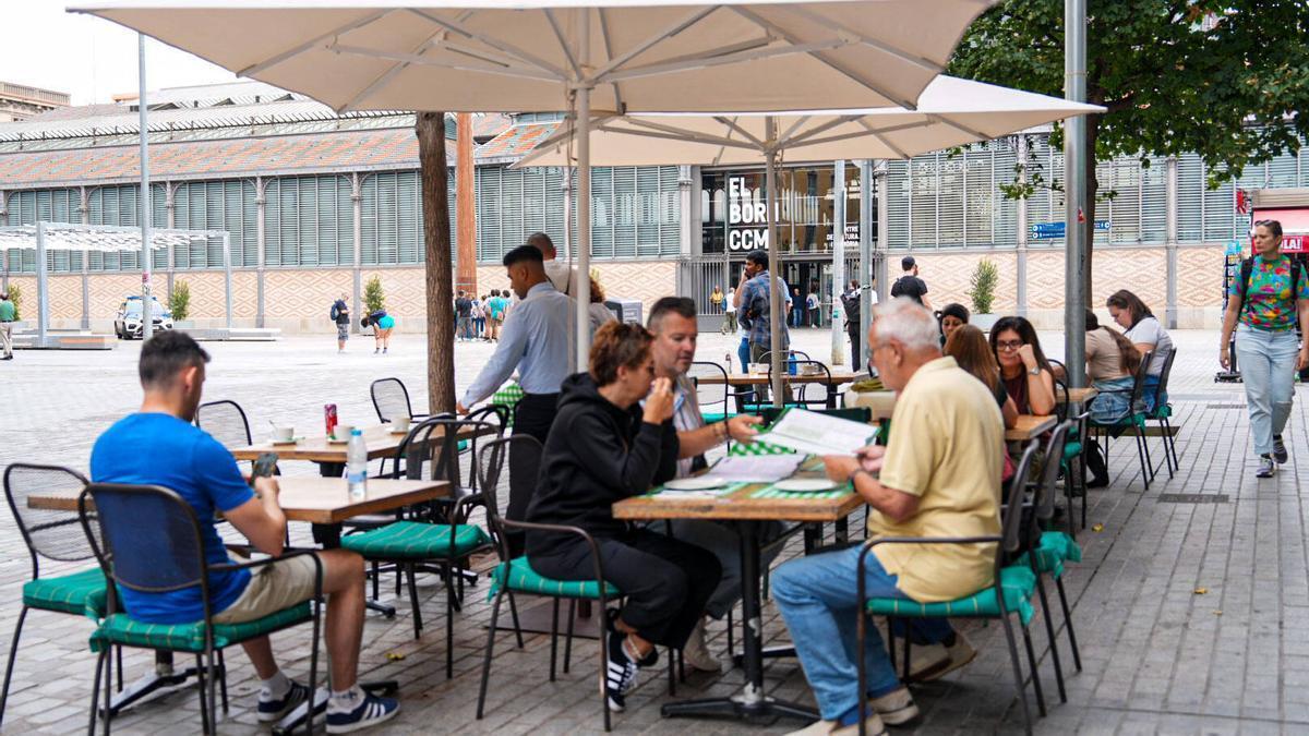 Una terraza de Barcelona, este octubre, con tazas de café, refrescos y un agua