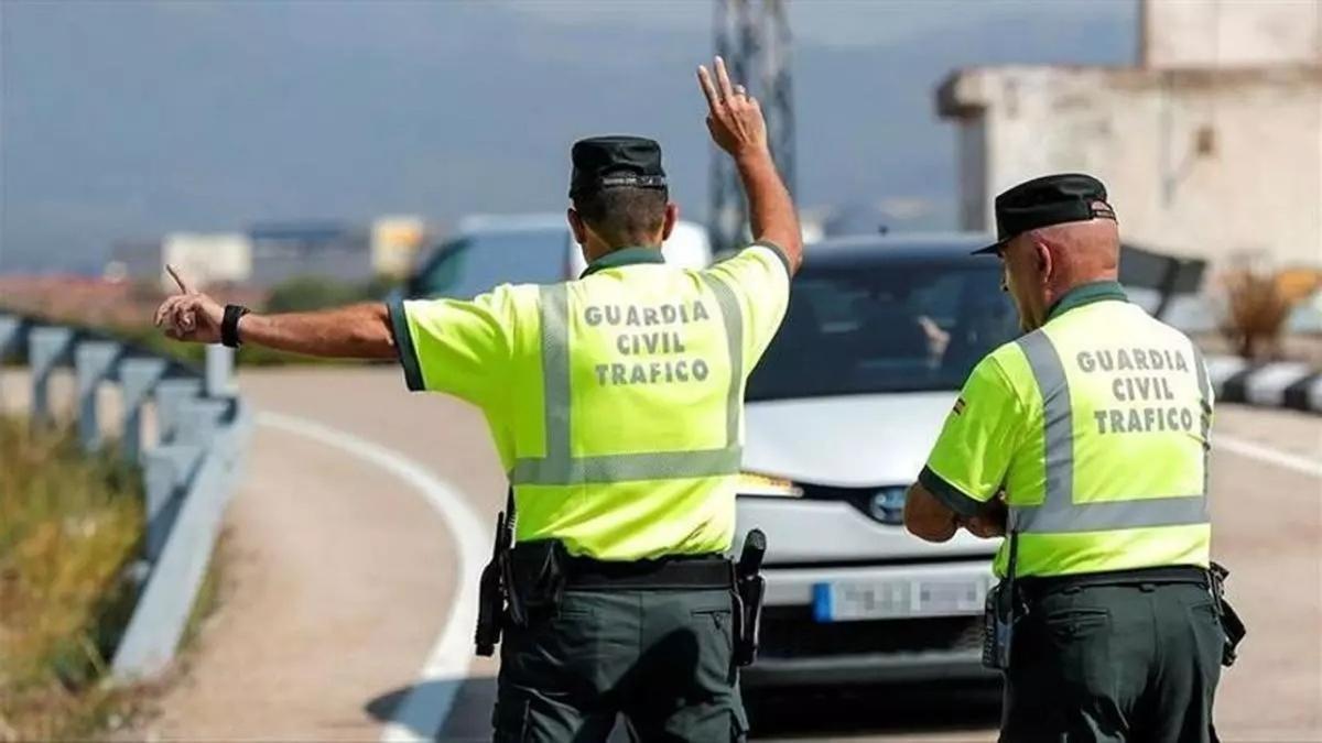 Guardias civiles del subsector de Tráfico ordenan la circulación en una carretera tras un accidente.