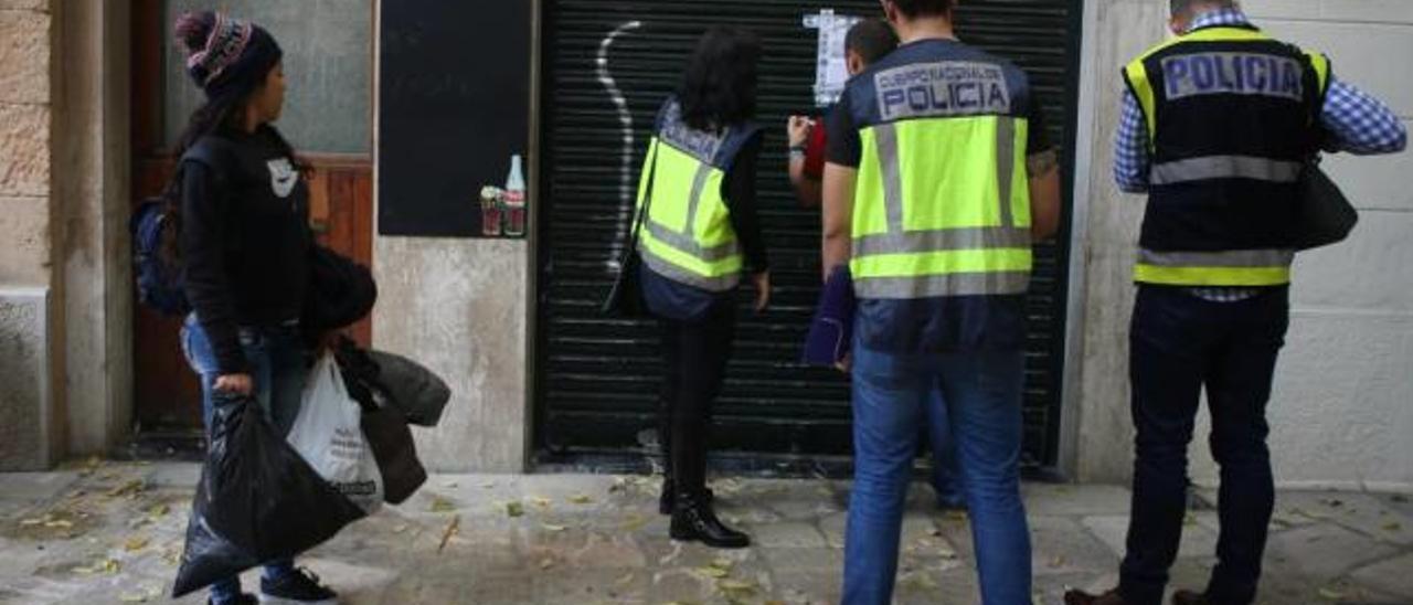 Una camarera mira cómo precintan el bar en el que trabaja.