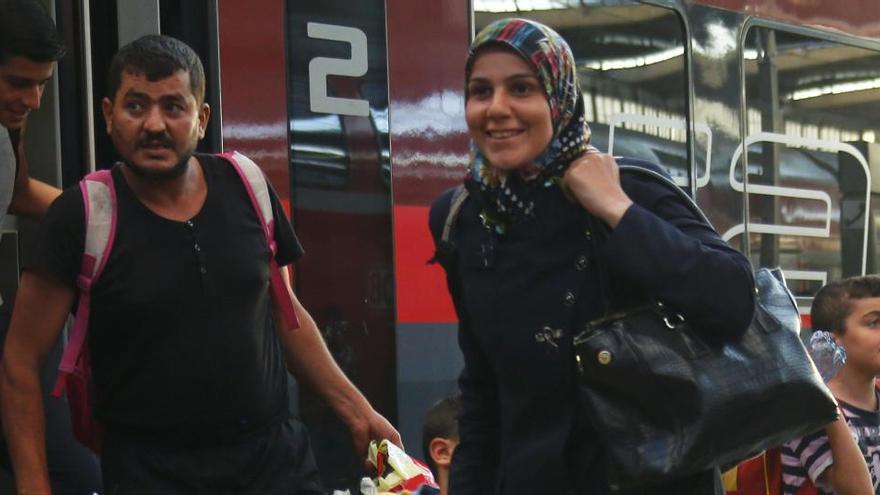 Una familia de refugiados bajan de un tren.