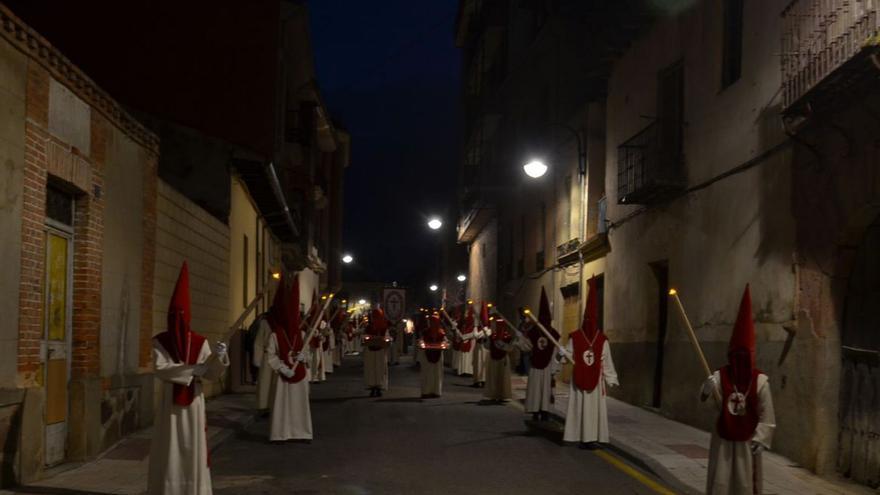 Arriba, cofrades del Santísimo Cristo de la Salud en la Procesión del Silencio que se celebra en la noche del Miércoles Santo a su paso por la calle Cervantes. Y abajo el Paso del Calvario tras salir de Santa María en la Procesión del Santo Entierro del Viernes Santo, llevada por Protección Civil. | E. P.