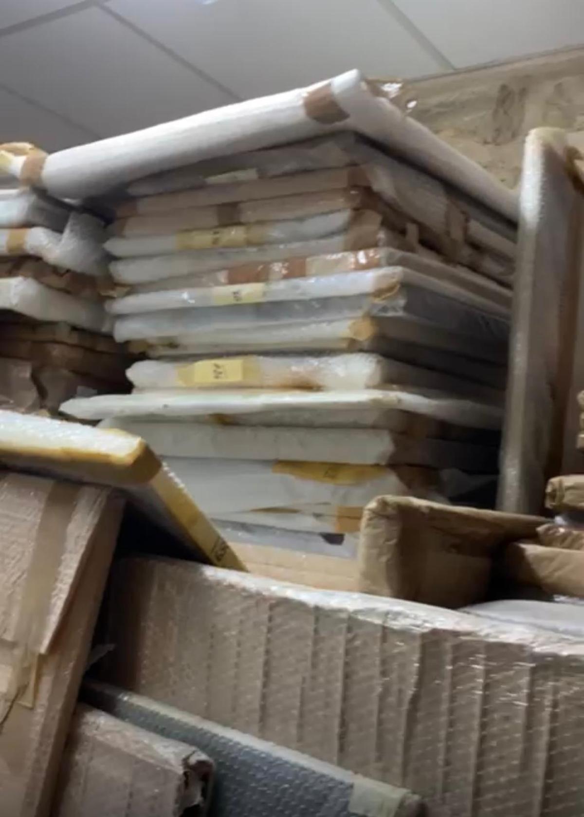 Una imagen con los grabados apilados en una estantería.